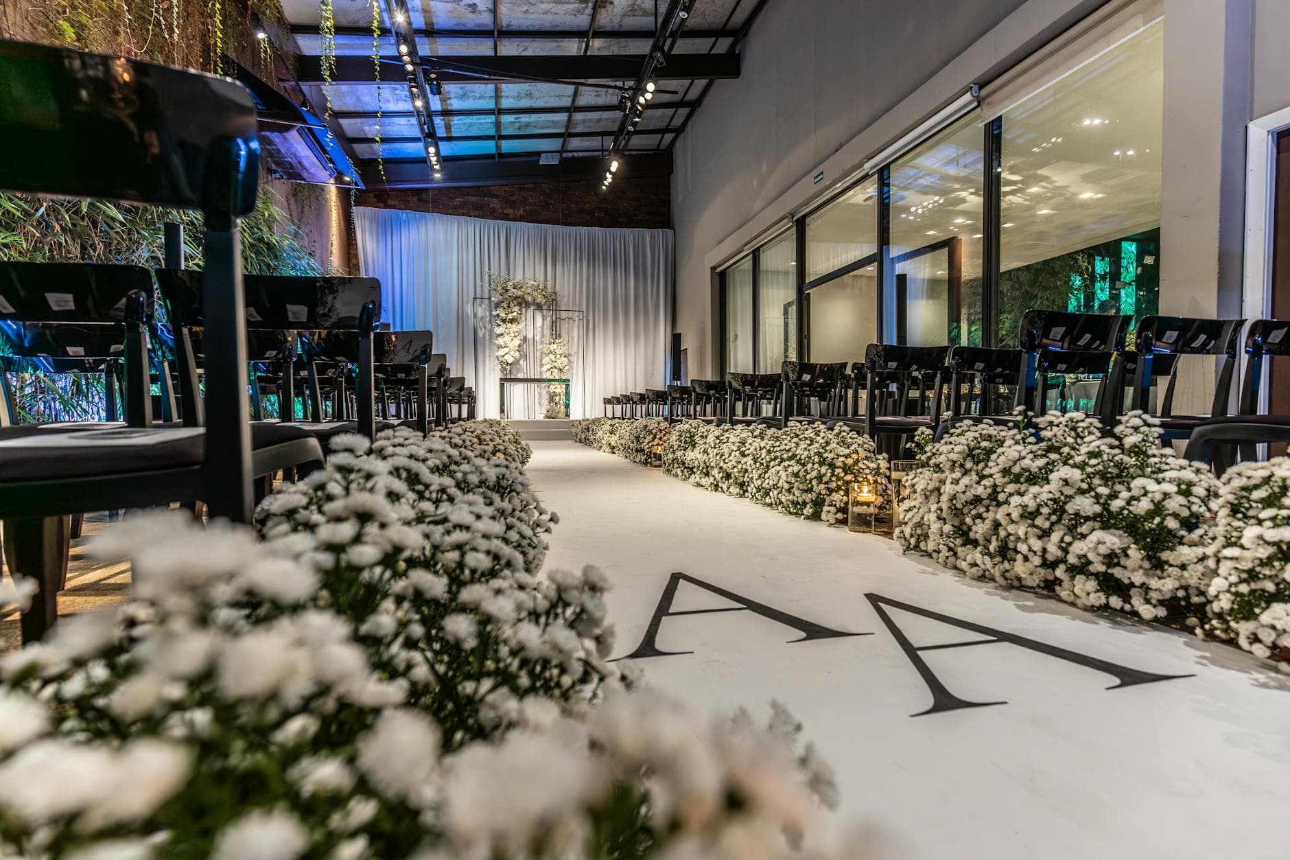 Black chiavari chairs lining a babies-breath wedding aisle