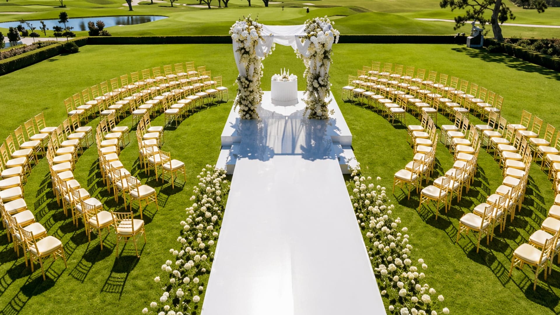 Outdoor wedding ceremony with gold chiavari chairs in a floral circle and a white floral arch, styled by Four Kees